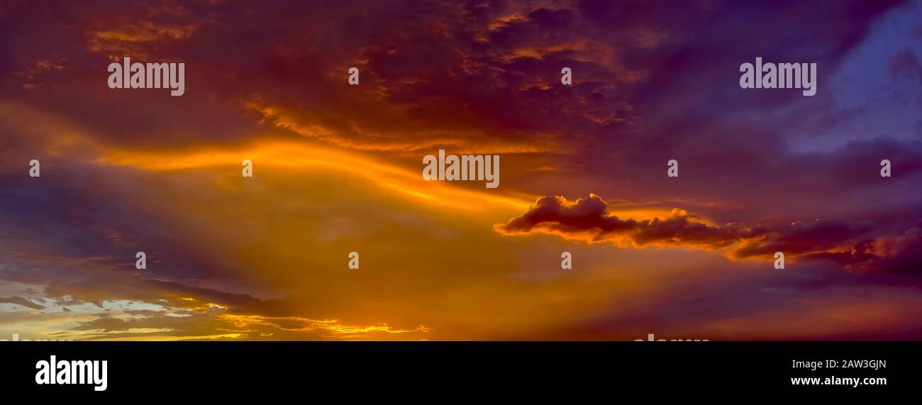 I raggi del sole che tramonta creano sfumature rosse e gialle sul lato inferiore di una tempesta di tarda giornata durante la stagione di Monsoon Arizona del 2014. Foto Stock