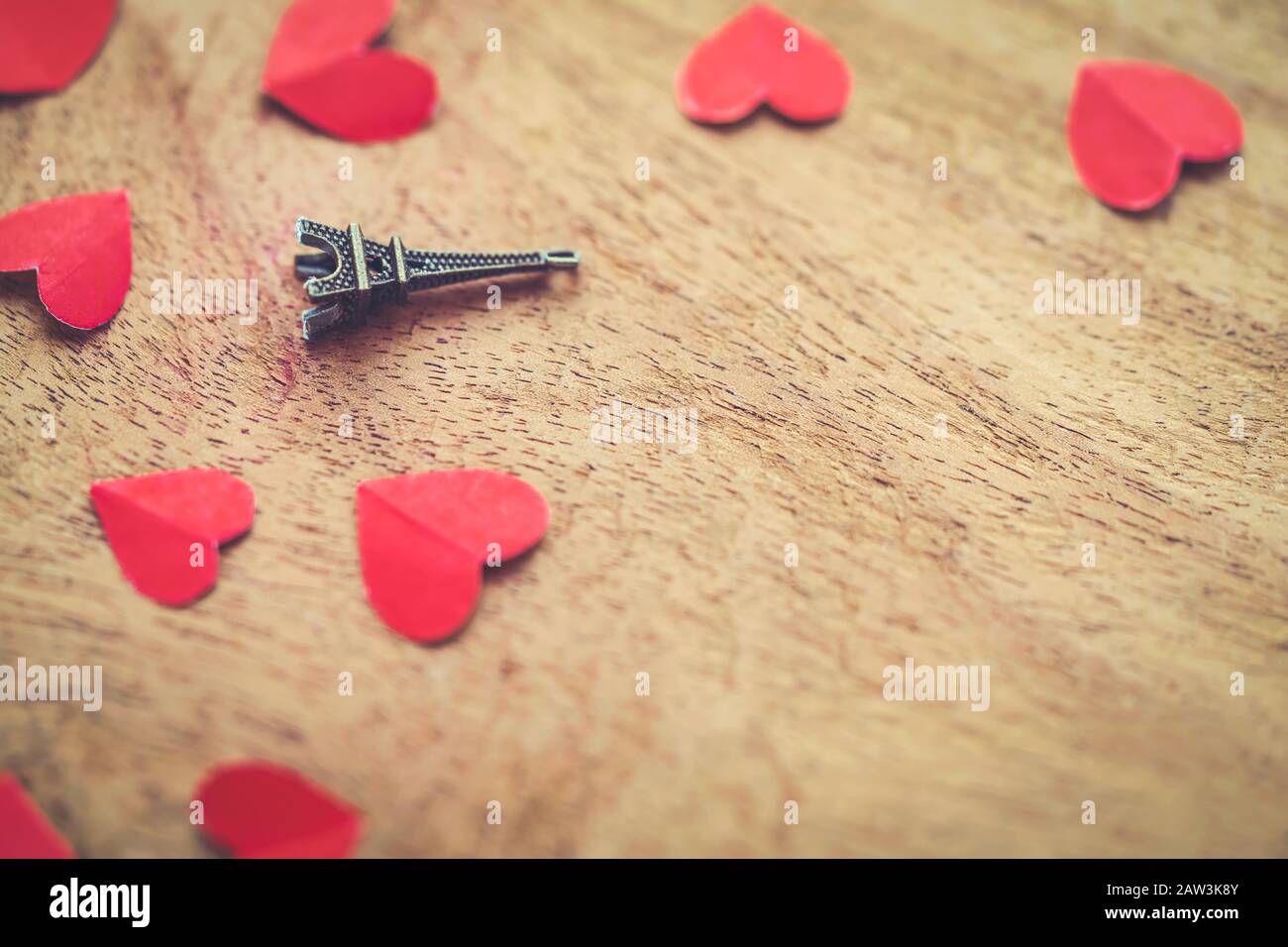 San Valentino romantico sfondo con spazio copia. Torre Eiffel in miniatura con piccoli cuori rossi su una superficie di legno. Concetto per regalo, invito, ca Foto Stock