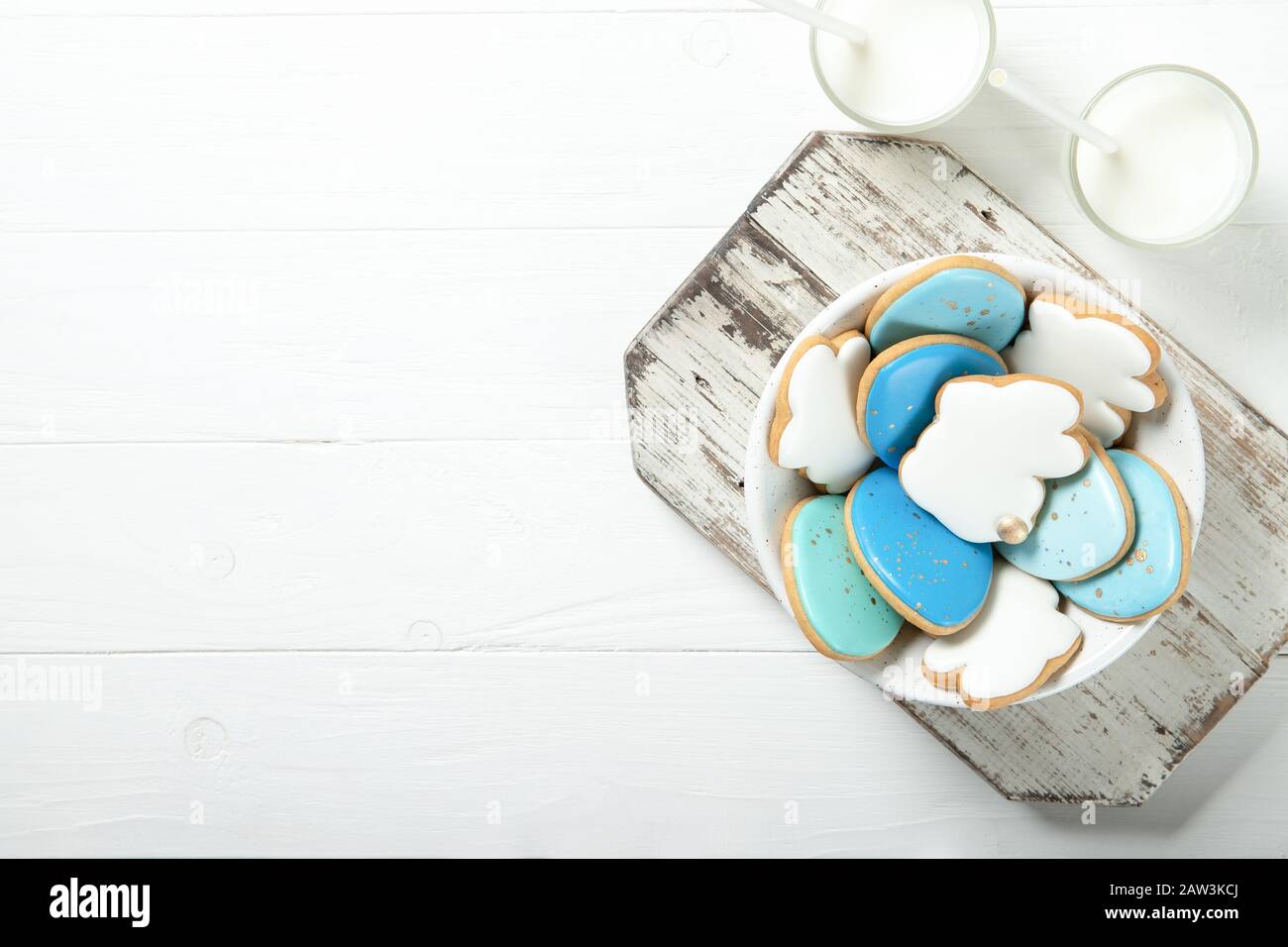 Biscotti di Pasqua in un piatto su uno sfondo concreto. Coniglietti di Pasqua. Inserire il testo. Vista dall'alto. Inserire il testo. Bicchiere di latte Foto Stock
