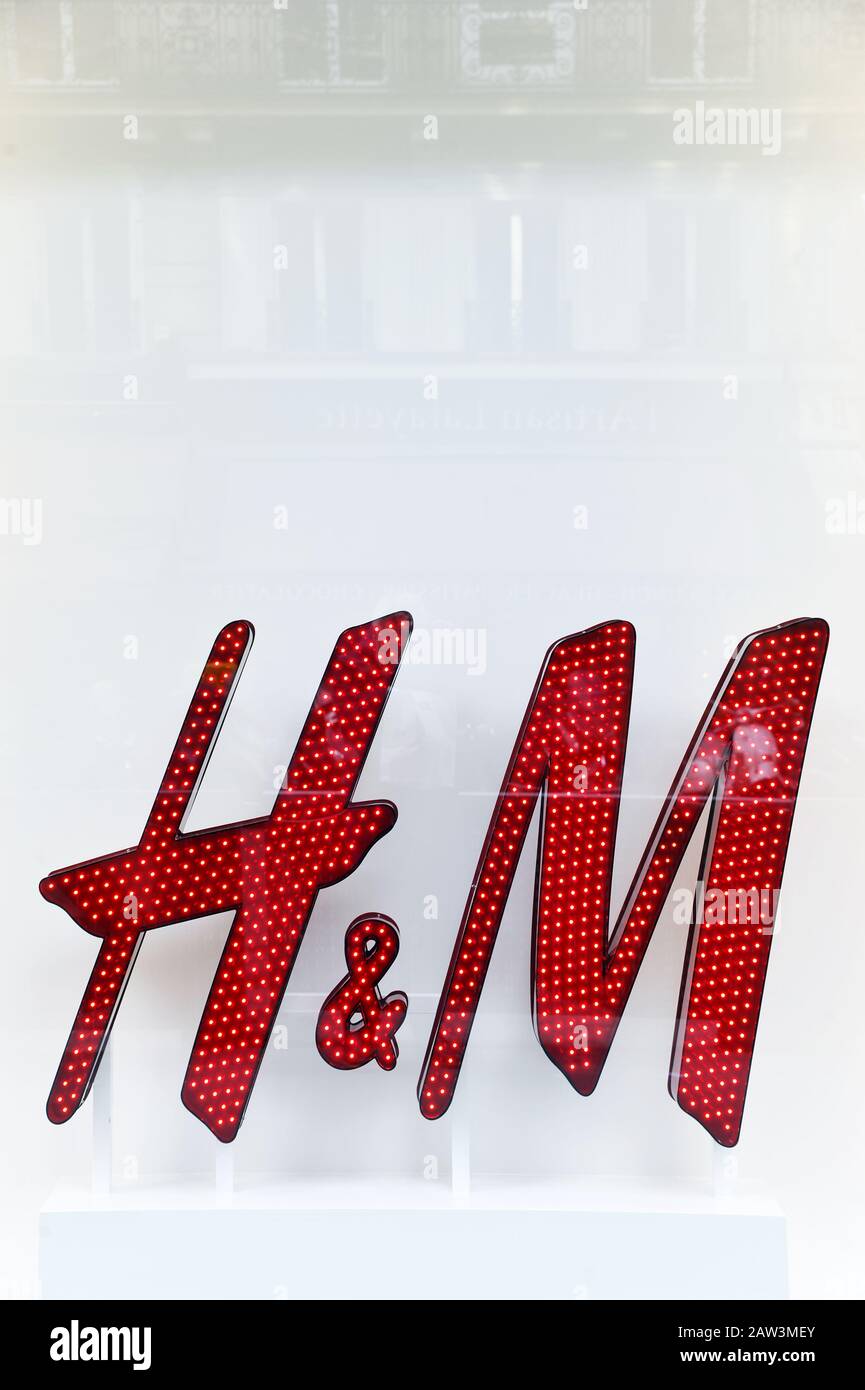 Un cartello decorativo rosso illuminato con il logo del marchio H&M e piccole luci incorporate - Parigi - Francia Foto Stock