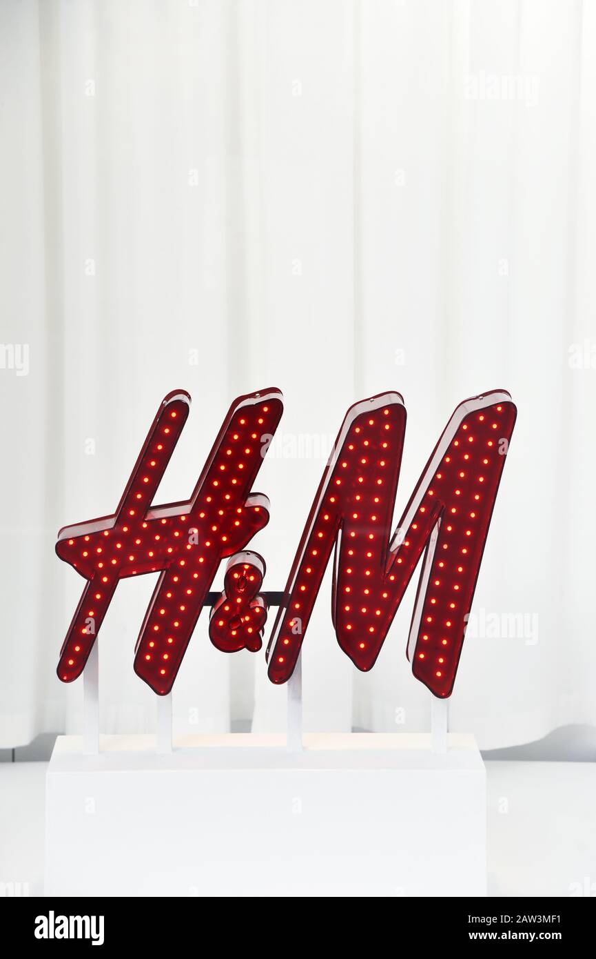 Un cartello decorativo rosso illuminato con il logo del marchio H&M e piccole luci incorporate - Parigi - Francia Foto Stock