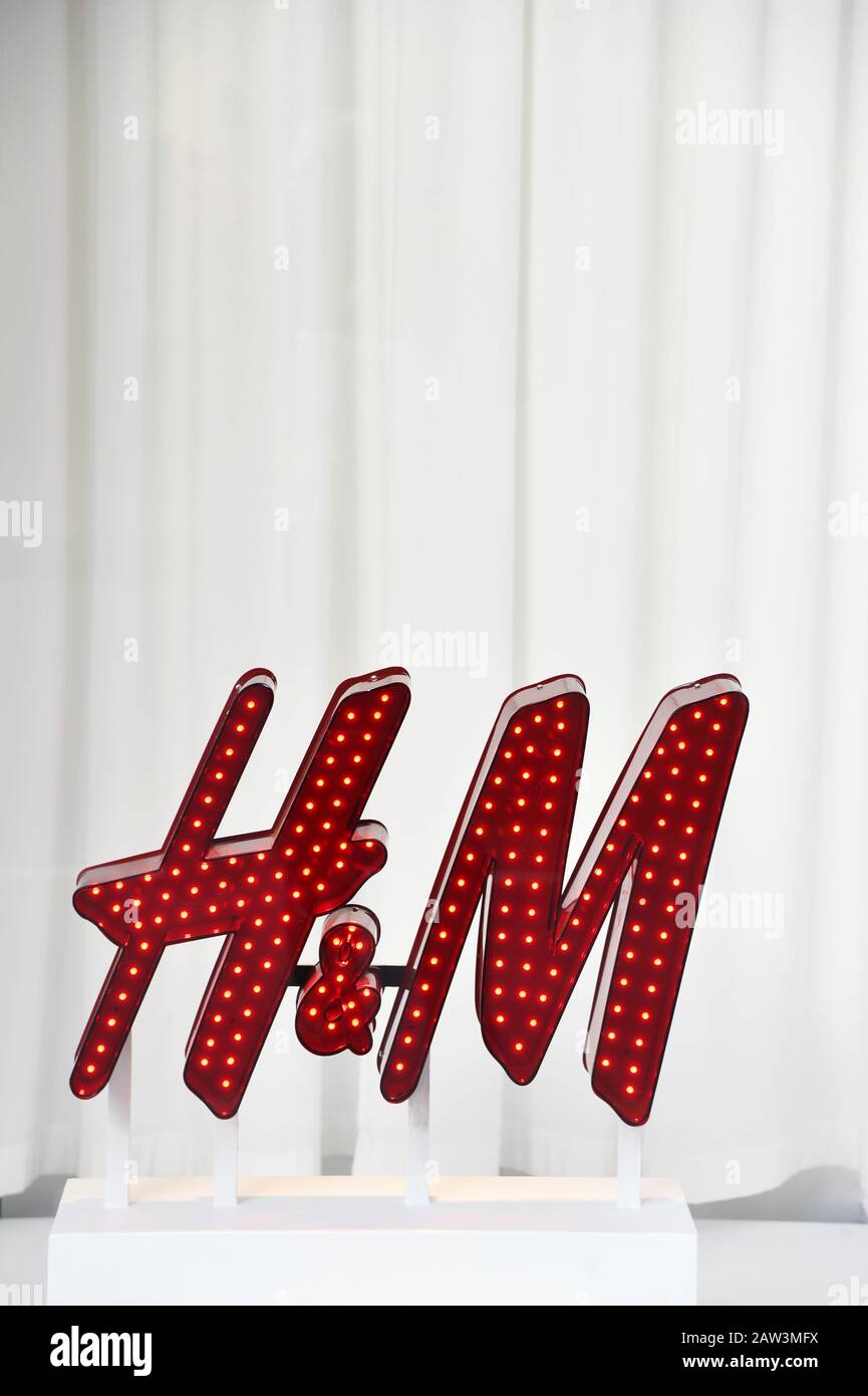 Un cartello decorativo rosso illuminato con il logo del marchio H&M e piccole luci incorporate - Parigi - Francia Foto Stock