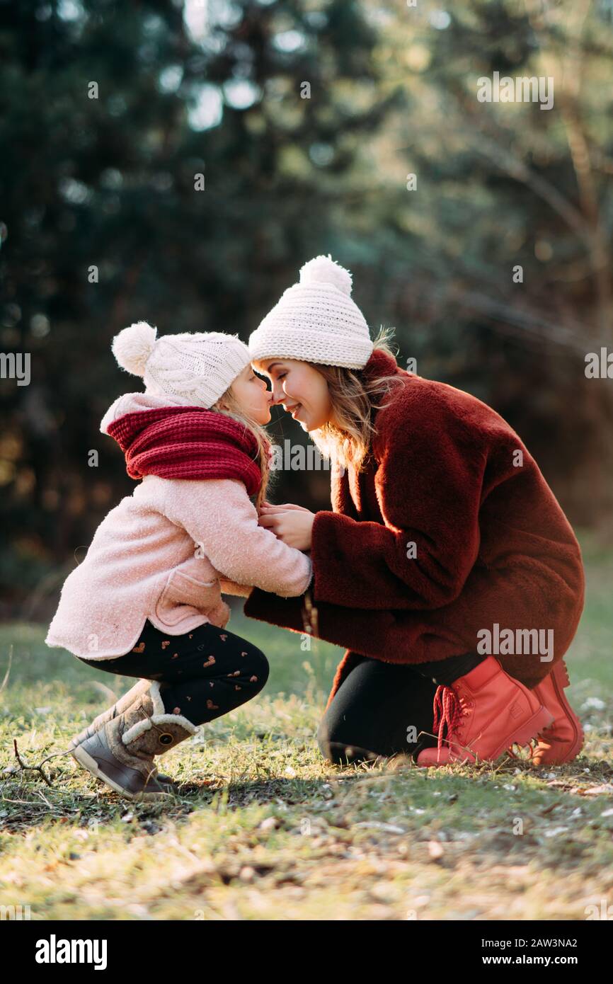 Madre e figlia giocano e si divertono camminando nella foresta. Foto Stock