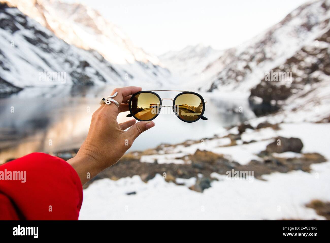 Un turista tiene un paio di occhiali da sole eleganti in montagna Foto Stock