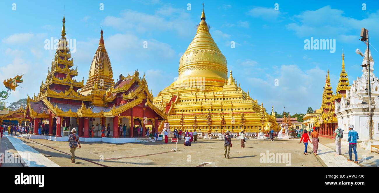 Bagan, MYANMAR - 25 FEBBRAIO 2018: Panorama dell'enorme stupa dorata del Tempio di Shwezigon, circondato da case ornate, piccole pagode e santuari wi Foto Stock