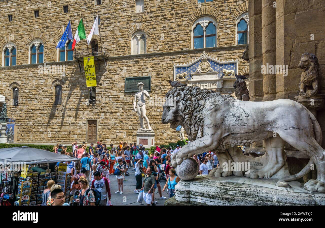 Leone mediceo di Flaminio Vacca a Loggia dei Lanzi sullo sfondo della Statua della Replica del David di Michelangelo, Piazza della Signoria, Firenze, T. Foto Stock