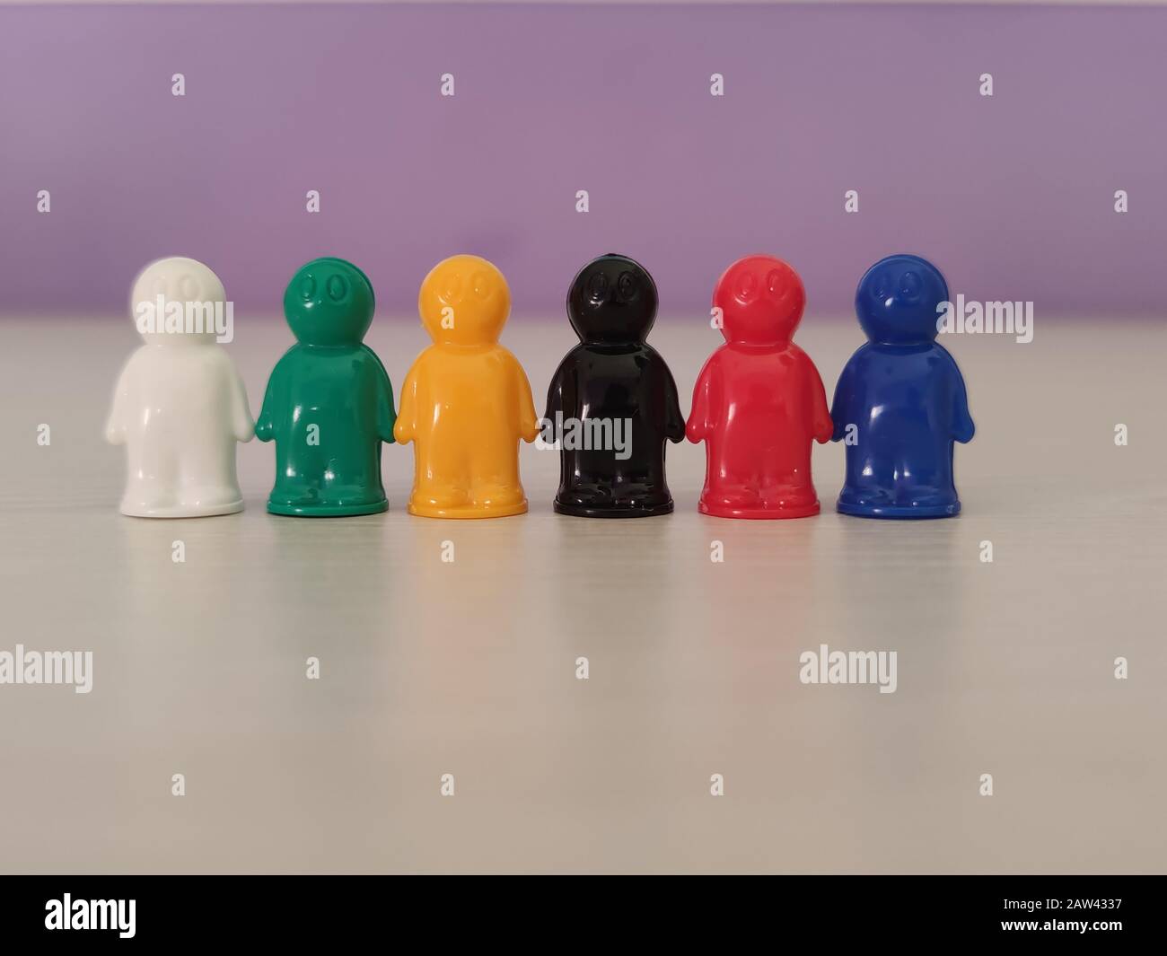 Concezione - lavorare in una squadra, cooperazione, adozione, figure di gioco o pedine in una situazione di affari. Chip colorati di gioco da tavolo nel piccolo me Foto Stock