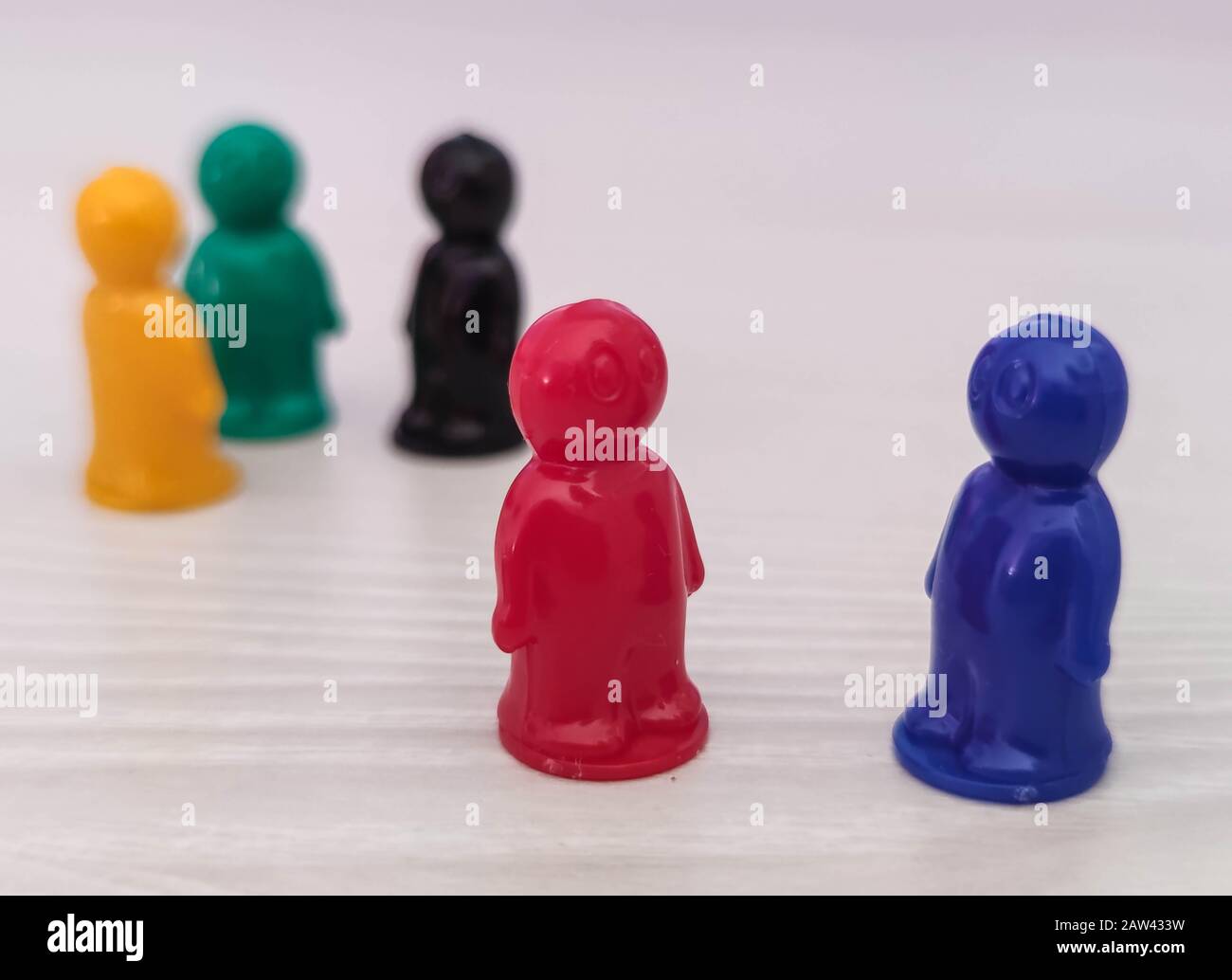 Concezione - lavorare in una squadra, cooperazione, adozione, figure di gioco o pedine in una situazione di affari. Chip colorati di gioco da tavolo nel piccolo me Foto Stock