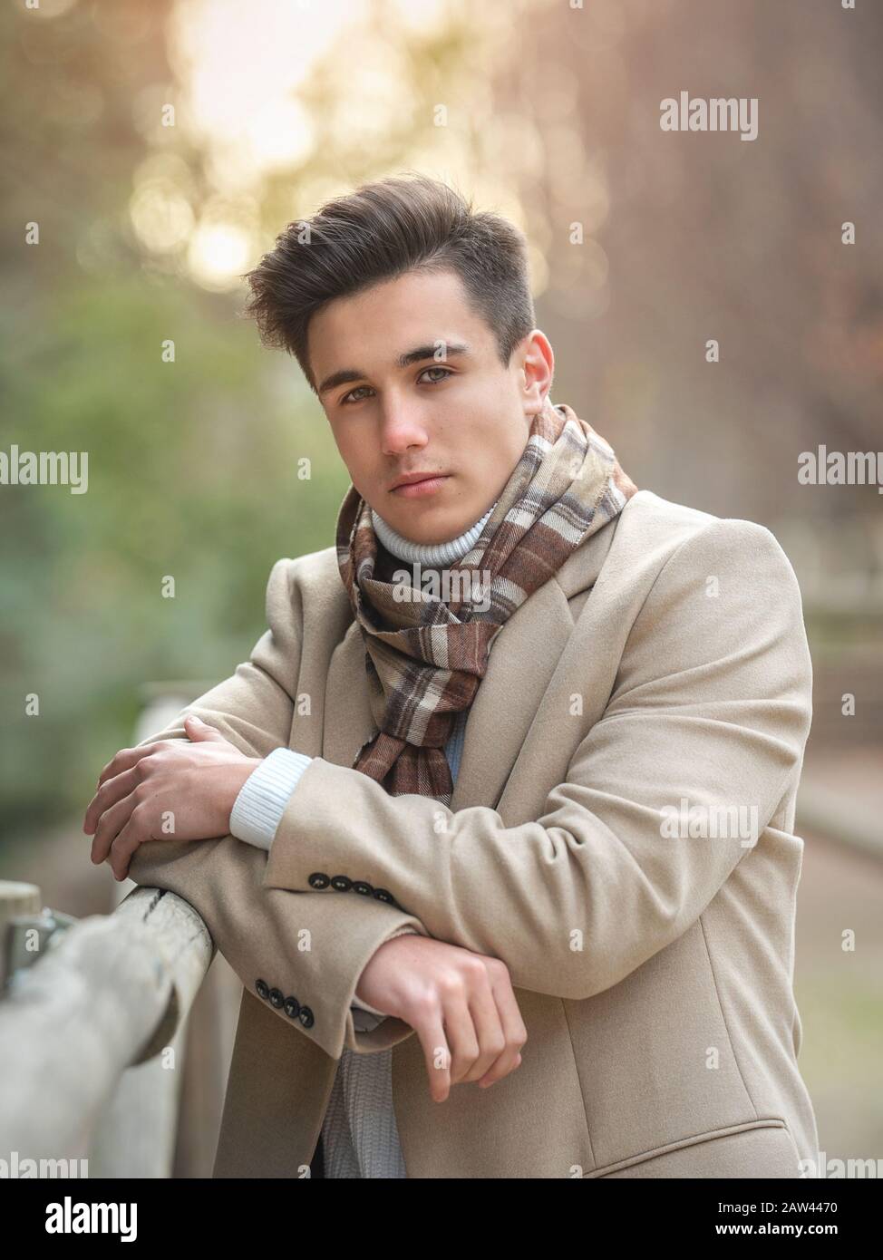 Ritratto di un giovane ragazzo sulla strada in un cappotto e sciarpa. Foto Stock