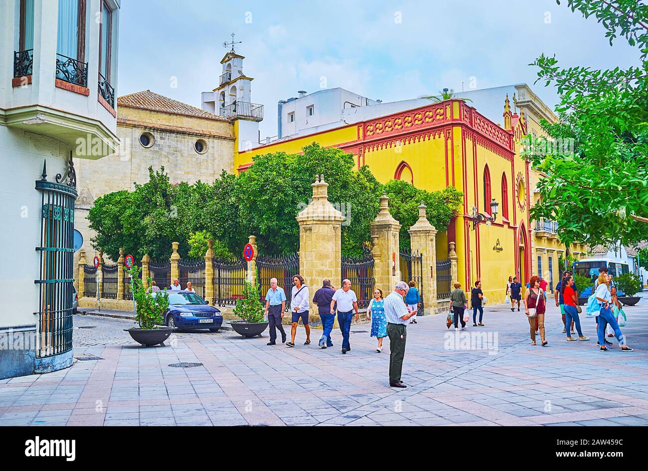 Jerez, SPAGNA - 20 SETTEMBRE 2019: Il vicolo affollato in piazza Plaza las Angustias con vista sulla chiesa della Santissima Trinità e la sua piccola corte di alberi d'arancio Foto Stock