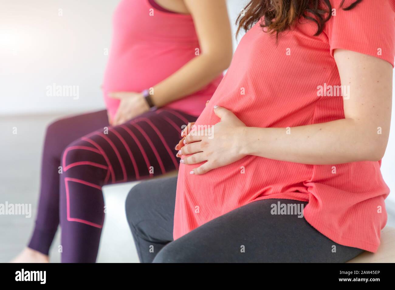 Le donne incinte stanno facendo yoga e maditition nella classe di yoga, lifestyle prenatale Sano Foto Stock