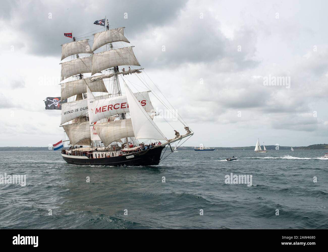 L'enorme nave a cinque gocce salpata, gemella, la Mercedes che vola il Jolly Roger, Skull e la bandiera a croce in una brezza rigida al largo di Falmouth. Foto Stock