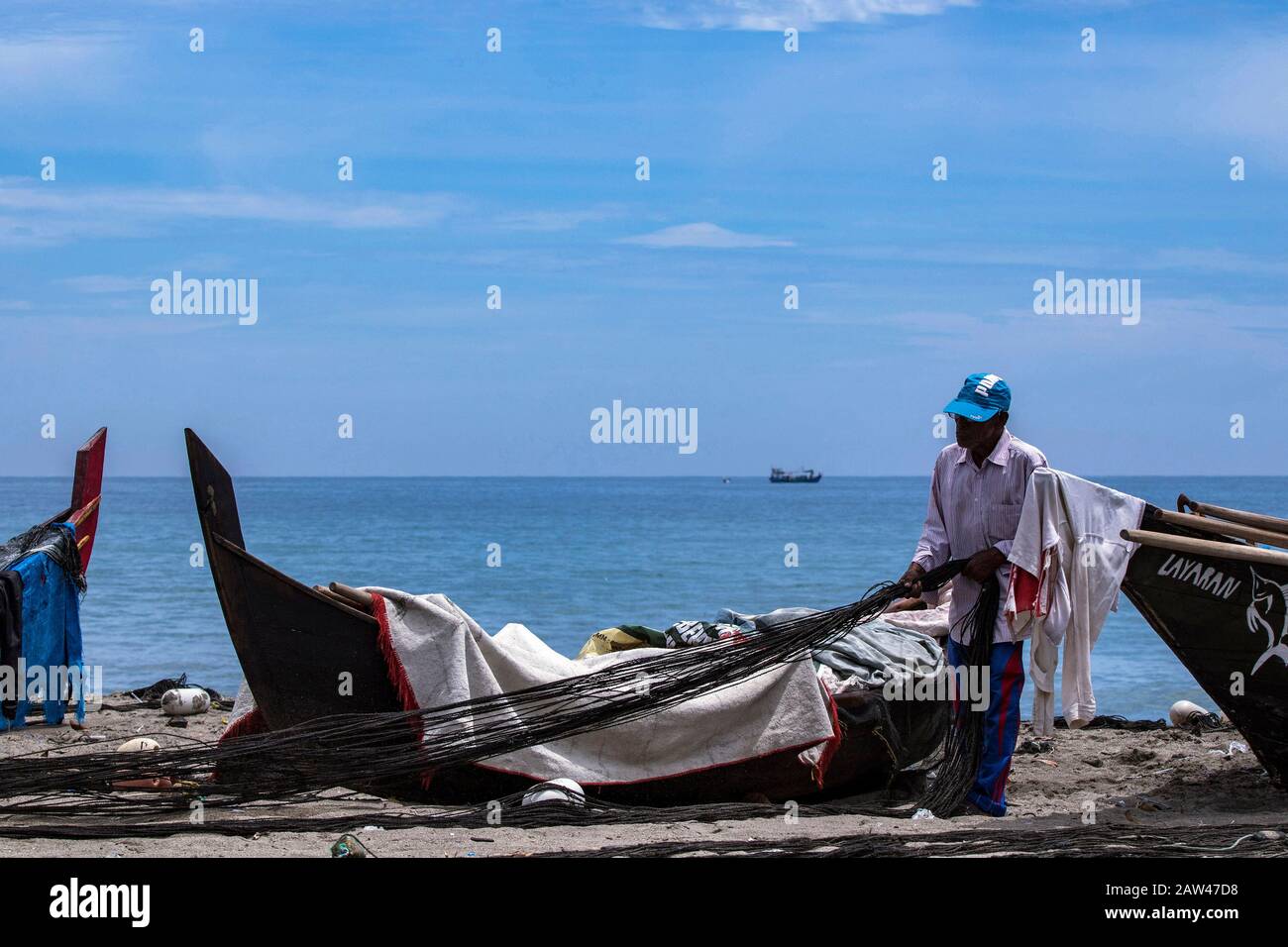 I pescatori tradizionali riparano le reti da traino tradizionali nella città di Lhokseumawe, provincia di Aceh, Indonesia, mercoledì 28 agosto 2019. Foto Stock