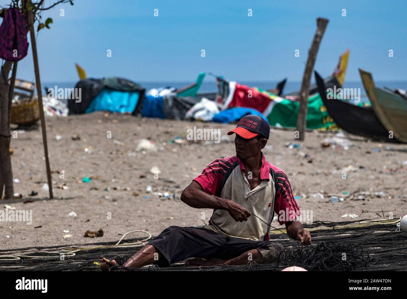 I pescatori tradizionali riparano le reti da traino tradizionali nella città di Lhokseumawe, provincia di Aceh, Indonesia, mercoledì 28 agosto 2019. Foto Stock