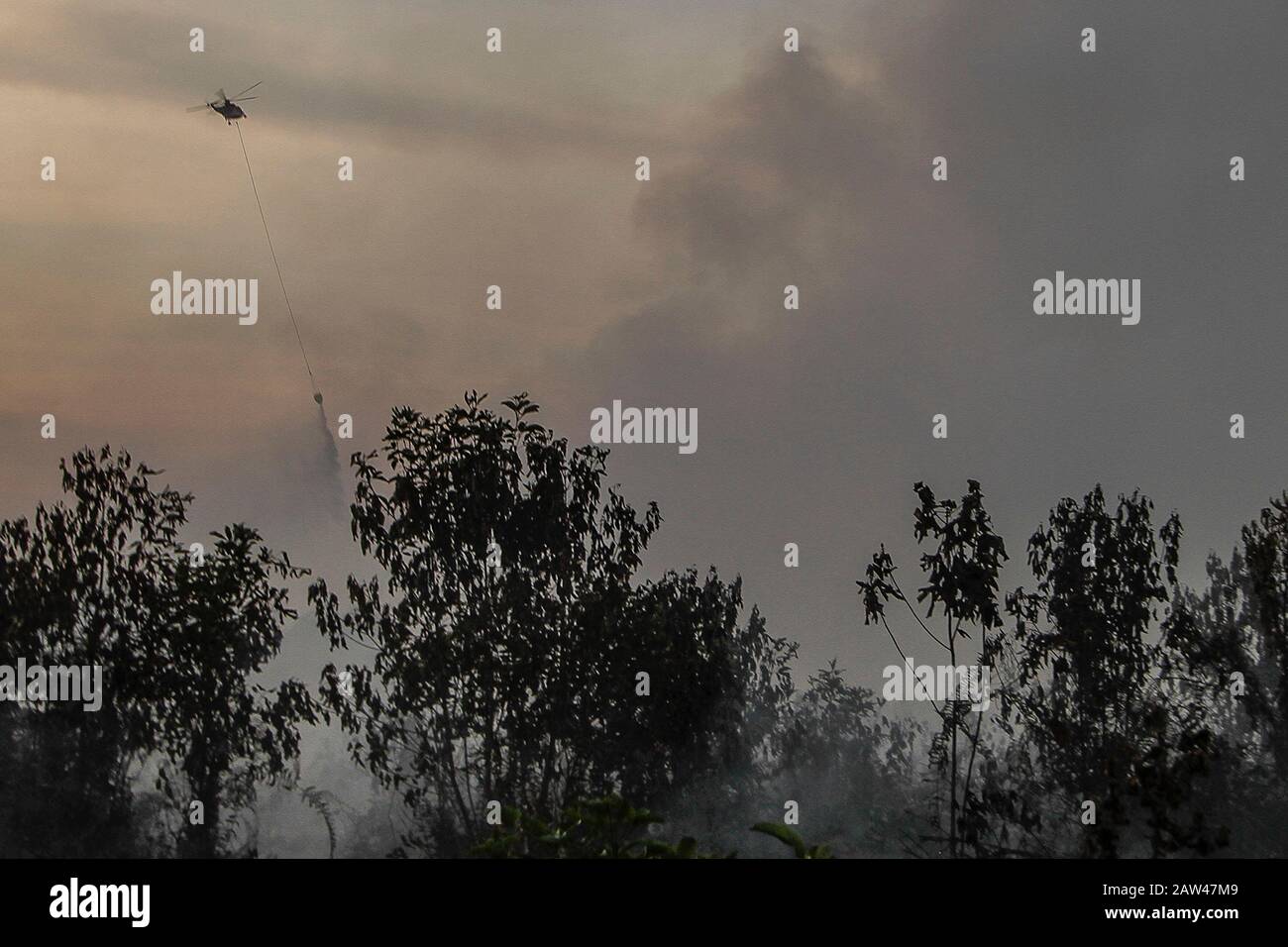 Un bombardamento d'acqua elicotteri cercare di spegnere incendi di terra nel villaggio di Rimbo Panjang, Kampar Regency, Riau, 6 ottobre 2019. Foto Stock