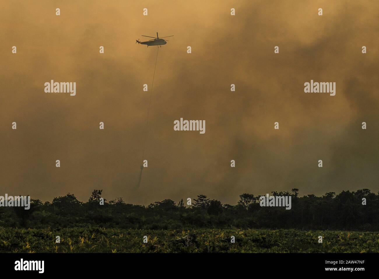 Un bombardamento d'acqua elicotteri cercare di spegnere incendi di terra nel villaggio di Rimbo Panjang, Kampar Regency, Riau, 6 ottobre 2019. Foto Stock