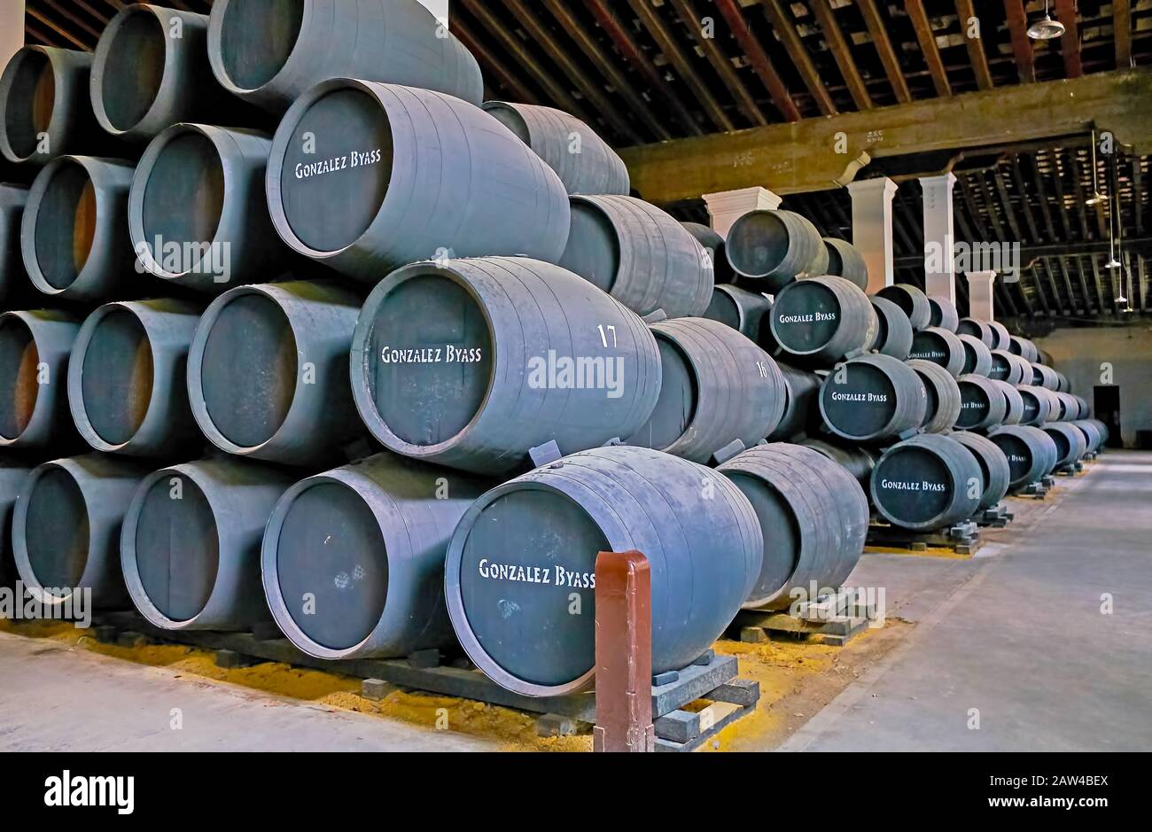 Jerez, SPAGNA - 20 SETTEMBRE 2019: La grande sala della cantina Bodegas Tio Pepe è piena di botti di rovere impilate con vino sherry, che invecchia a terra, a causa Foto Stock