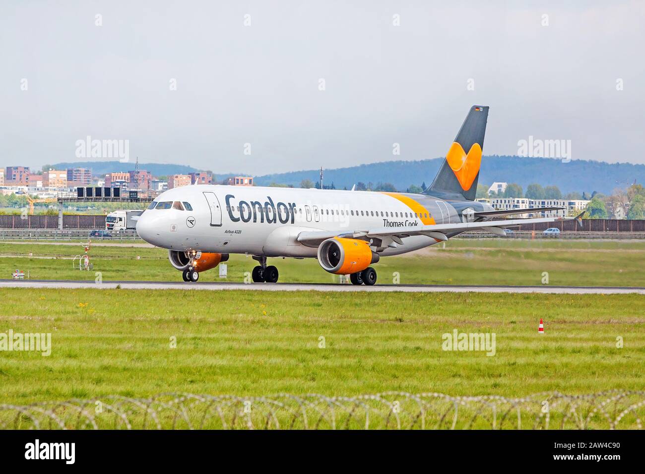 Stoccarda, Germania - 29 aprile 2017: Aeromobile Airbus A320 da Condor a terra (aeroporto di Stoccarda) prima del decollo - prato verde con recinzione di fronte Foto Stock