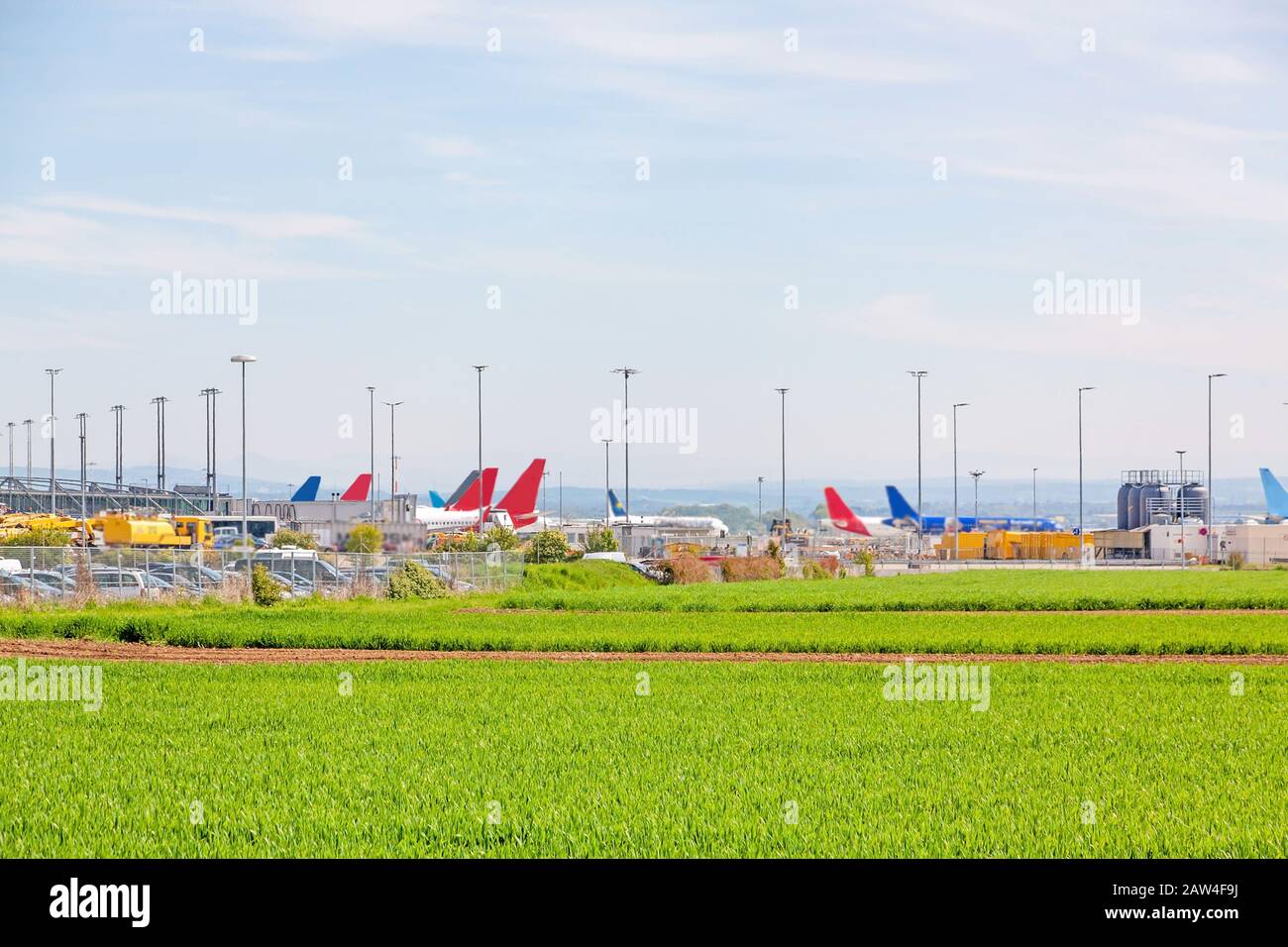 Aeroporto di Stoccarda, aerei di diverse compagnie aeree in posizione di parcheggio di fronte al terminal, campo verde in primo piano Foto Stock