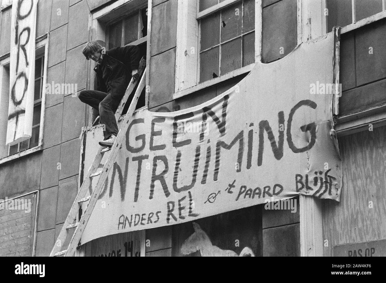 Squat di evacuazione Amstel 134/136 Adam Squatter lasciare l'edificio attraverso la finestra Data: 3 ottobre 1983 luogo: Amsterdam, Noord-Holland Parole Chiave: Cracker, evictions, banner Foto Stock