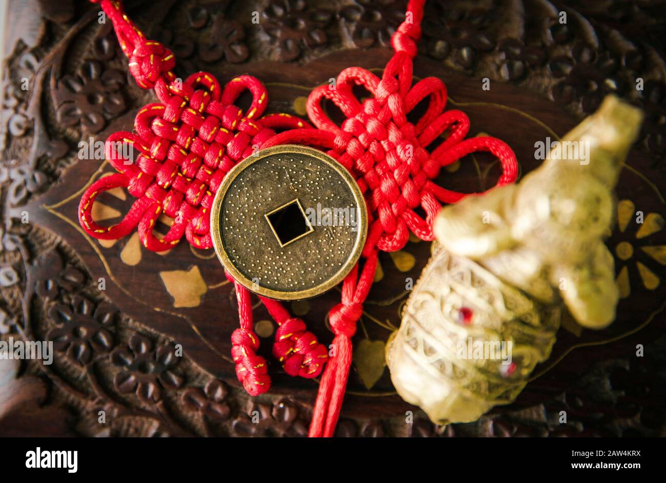 La moneta cinese usata come cura di soldi di Feng Shui che attrae l'energia del concetto di ricchezza e di soldi. Sfondo orientale in legno. Foto Stock