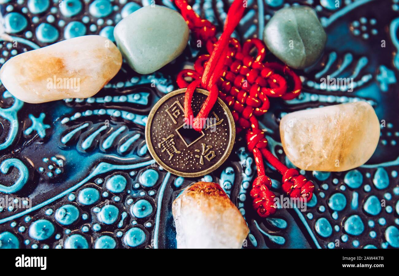 La moneta cinese usata come cura di soldi di Feng Shui che attrae l'energia del concetto di ricchezza e di soldi. Sfondo orientale in legno. Foto Stock