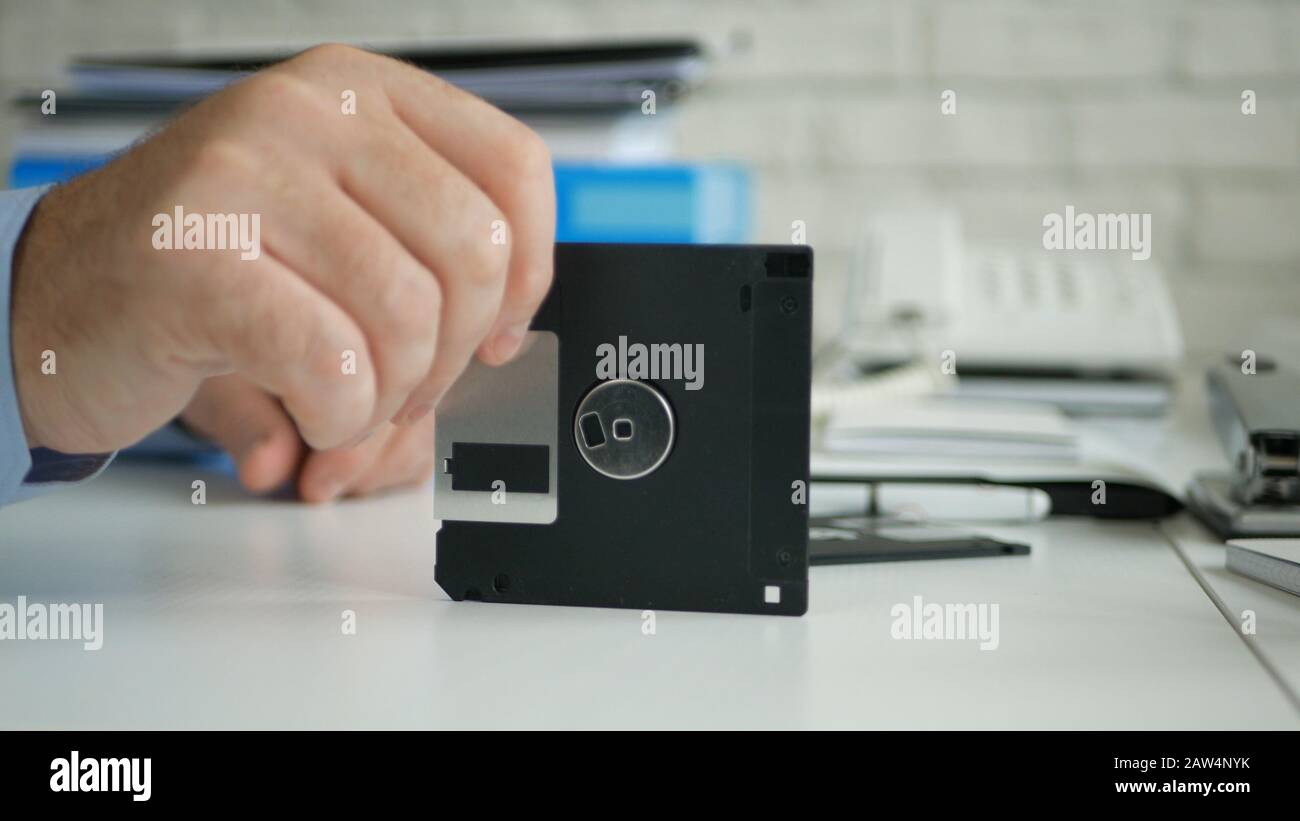Immagine con Un Businessperson in Office Room Tenendo Un floppy Disk In Mano Foto Stock