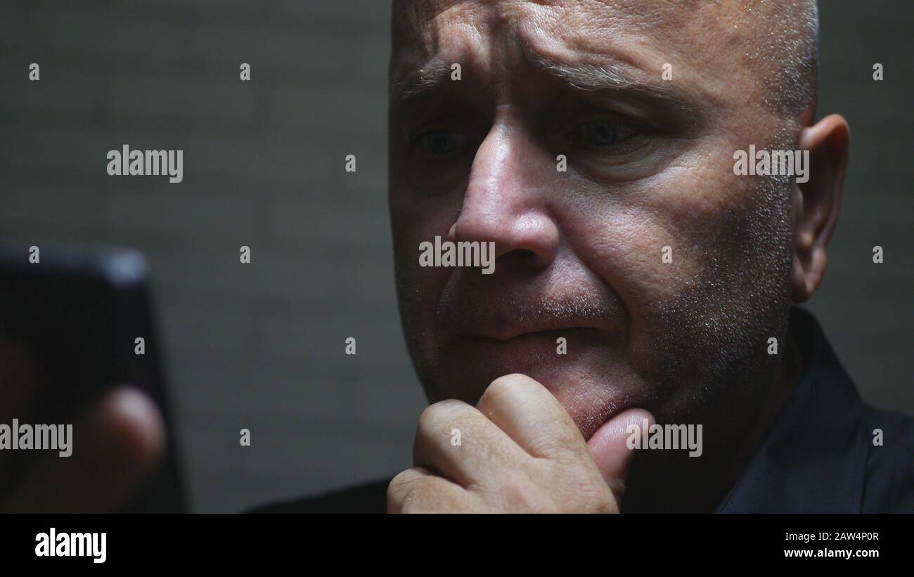 Immagine Di Un Uomo D'Affari Preoccupato In Una Stanza Buia Usando La Comunicazione Senza Fili Dello Smartphone Che Legge I Messaggi E Le Email Foto Stock