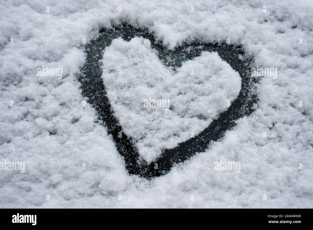 Disegno di forma di cuore su una finestra di automobile innevata durante una tempesta di neve all'aperto, sfondo, Montreal, Quebec, Canada Foto Stock