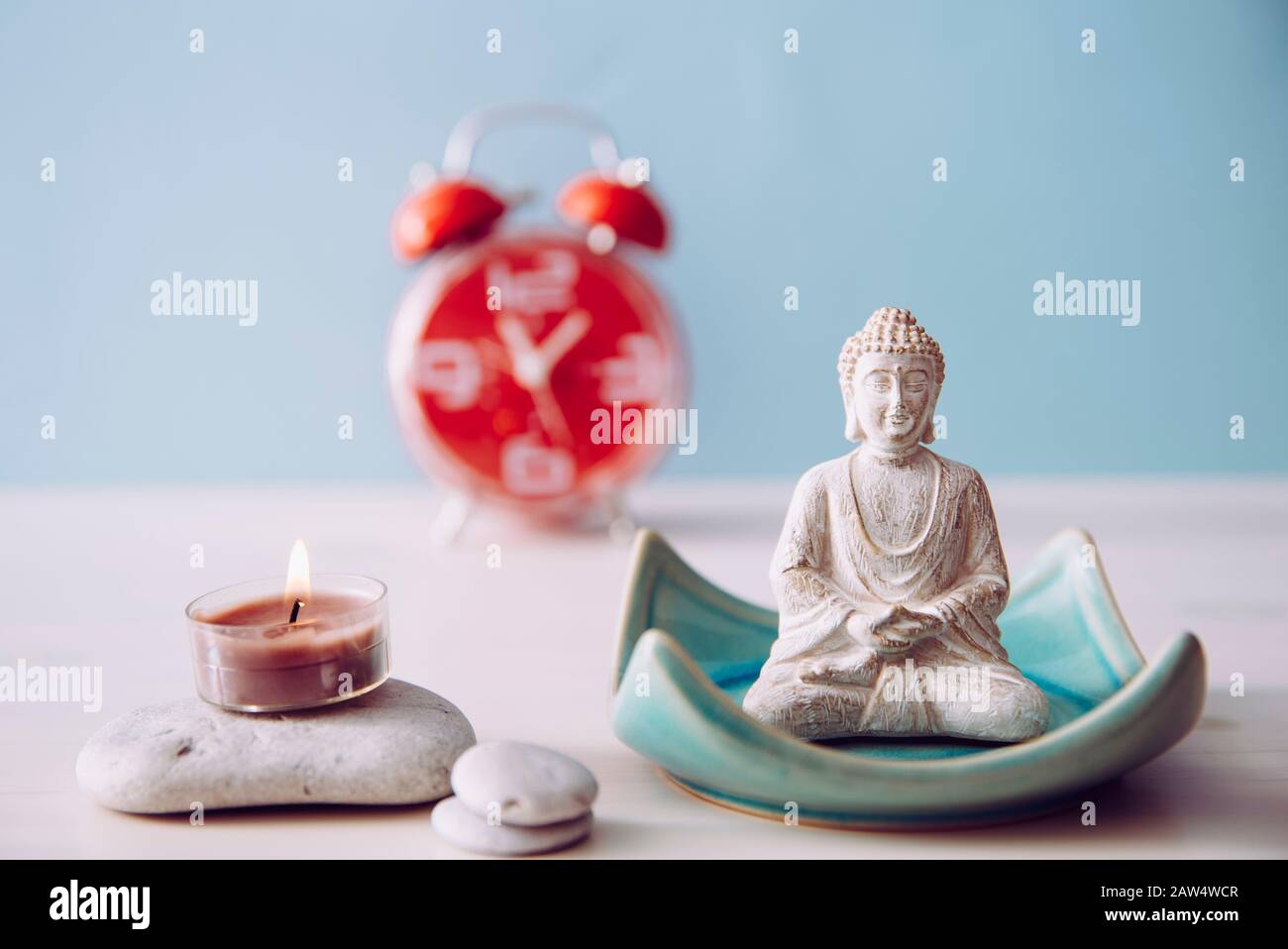 Trovare il tempo per la cura di sé e l'equilibrio tra anima e mente del corpo. Equilibrio tra concetto di lavoro e concetto di casa. Lotus posa bianco colore seduta meditazione Bu Foto Stock