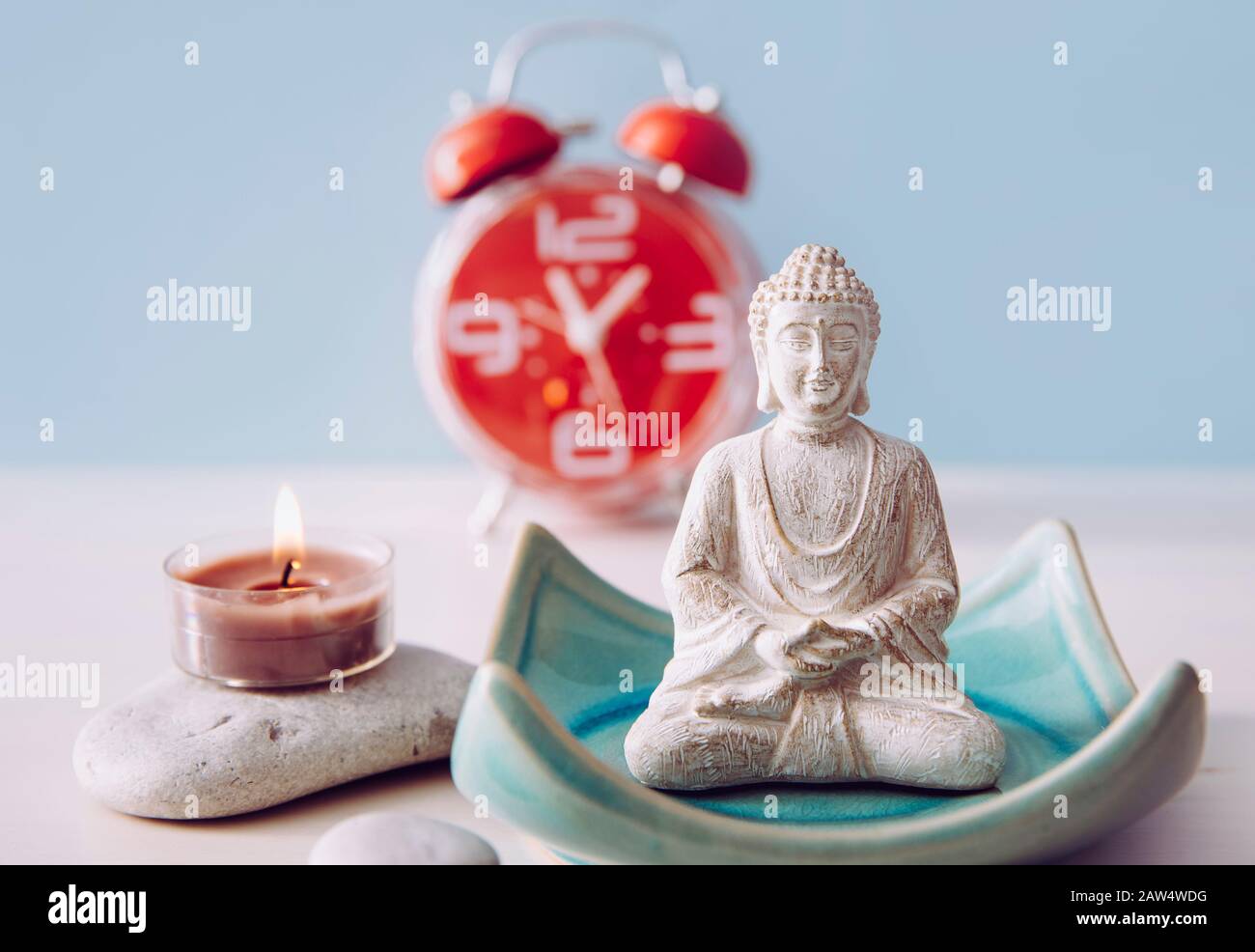 Trovare il tempo per la cura di sé e l'equilibrio tra anima e mente del corpo. Equilibrio tra concetto di lavoro e concetto di casa. Lotus posa bianco colore seduta meditazione Bu Foto Stock