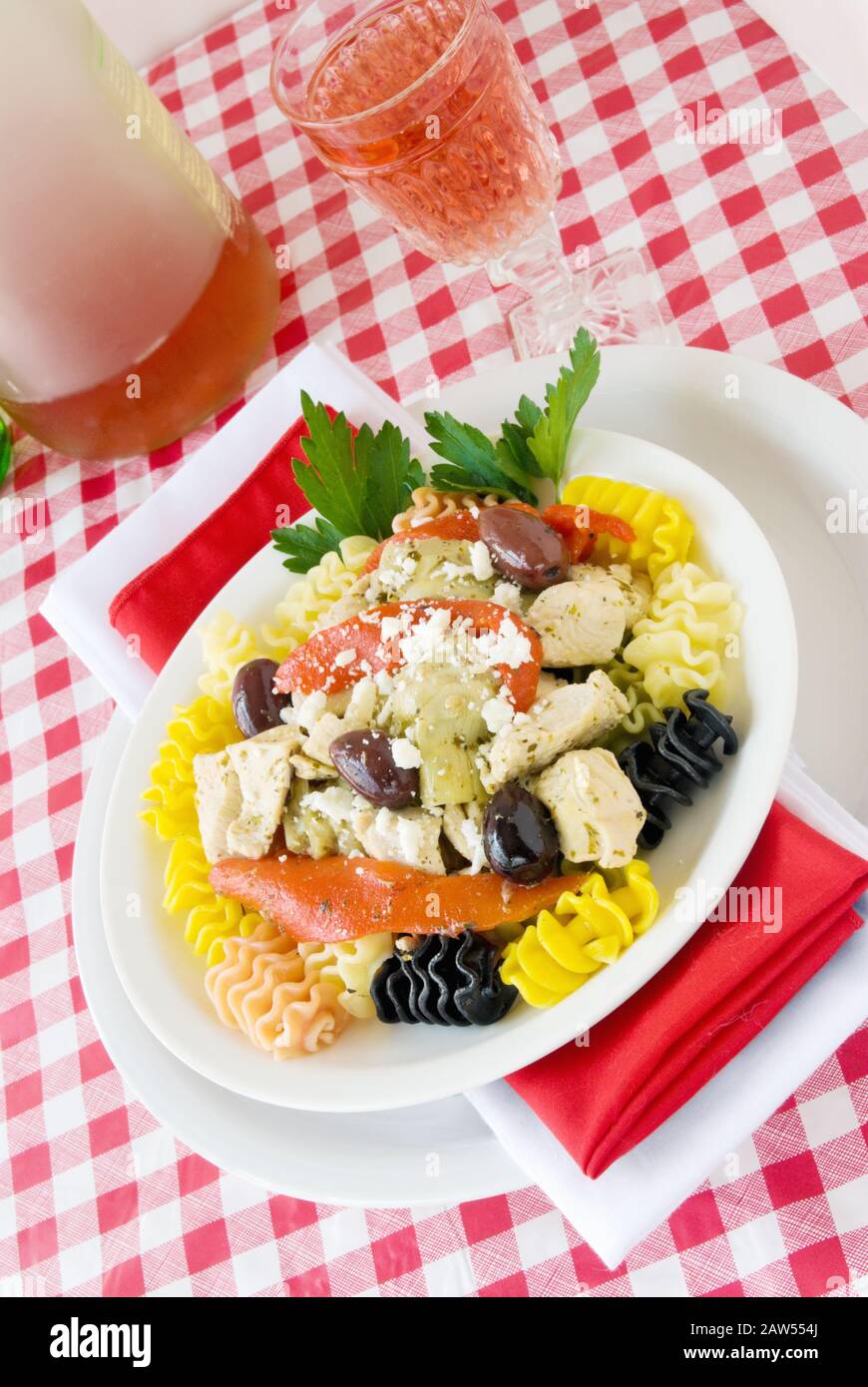 Cena a base di pollo e pasta mediterranea a base di verdure fresche e cuori di carciofi e formaggio feta. Prospettiva angolata. Foto Stock