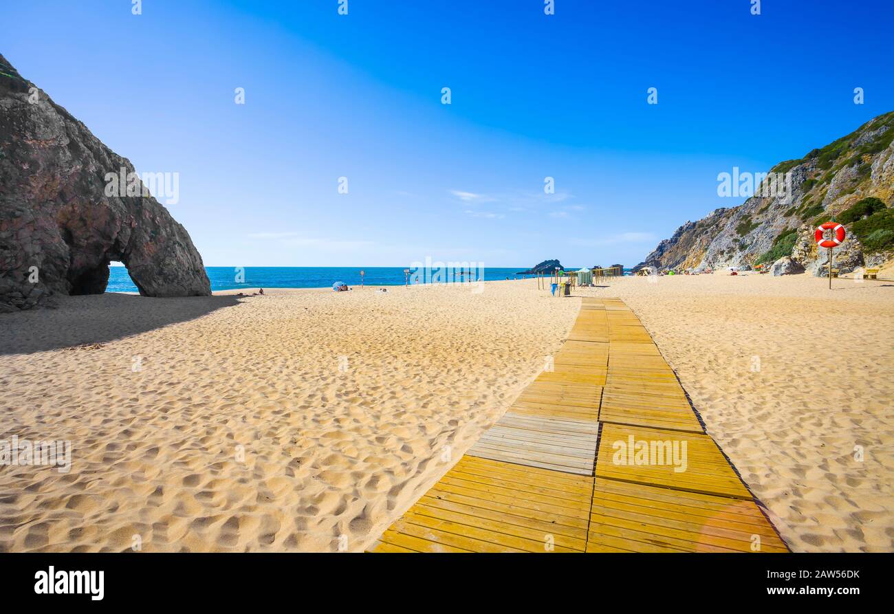 Adraga spiaggia paesaggio e arco di roccia, oceano Atlantico. Almocageme, Sintra, Portogallo Foto Stock