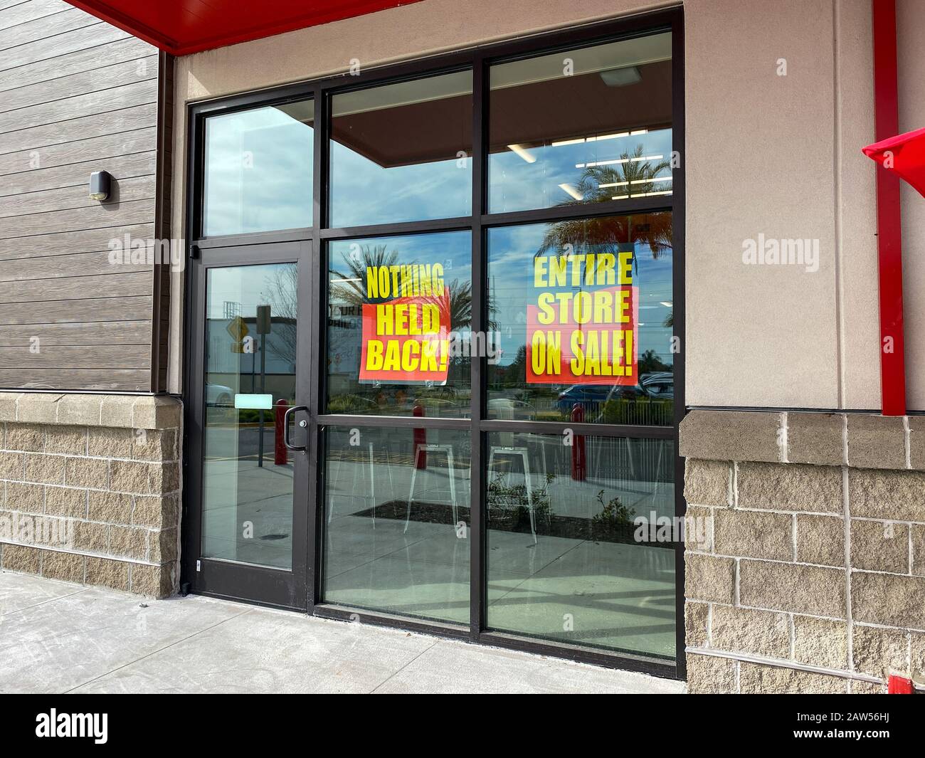 Orlando, FL/USA-2/4/20: Segni nella finestra di un negozio di generi alimentari Earthfare che esce dal commercio che dicono l'intero negozio in vendita, tutto m Foto Stock