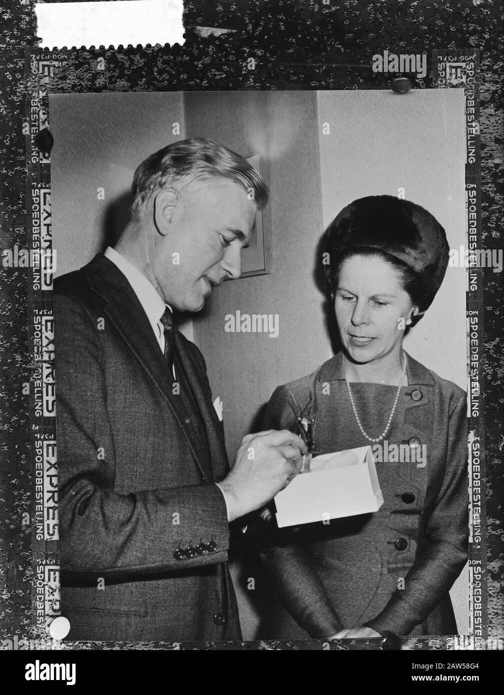 Uomo che guarda i contenuti di una scatola e di una donna orologi Data: 1 marzo 1962 Foto Stock