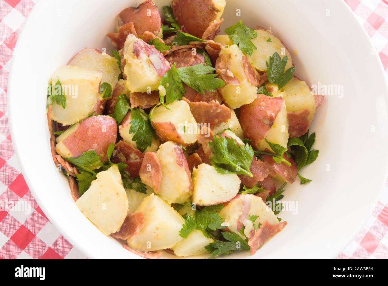 Vista dall'alto della salutare insalata di patate fatta in casa con pancetta di tacchino e condimento con vinaigrette. Foto Stock