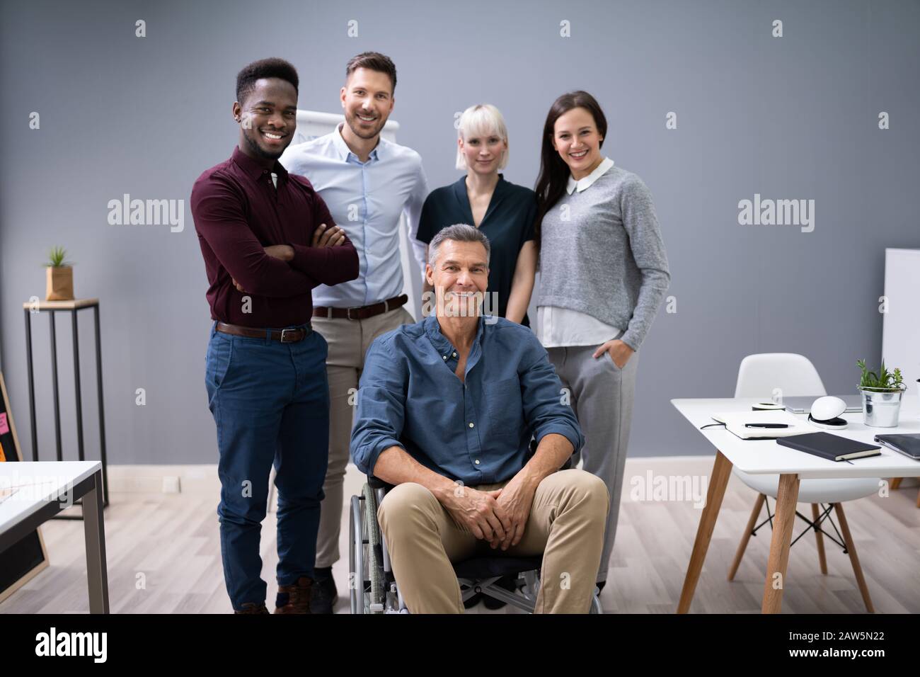 Gruppo di Felice imprenditori e multirazziale in piedi in ufficio Foto Stock