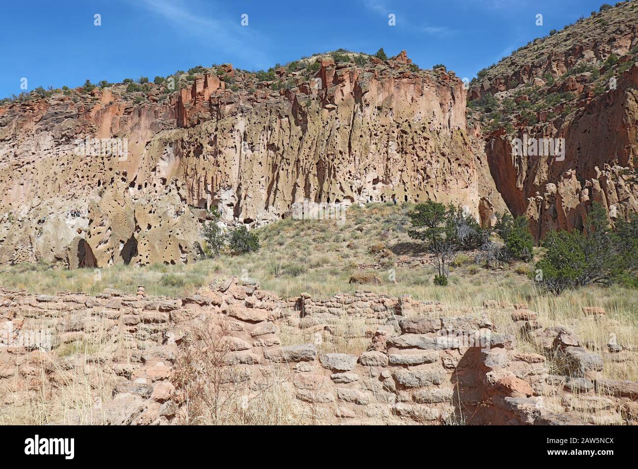 Parte delle rovine Tyuonyi dei popoli ancestrali Pueblo con un pueblo ricostruito dalle scogliere lungo il percorso principale del Canyon Frijoles a Ba Foto Stock