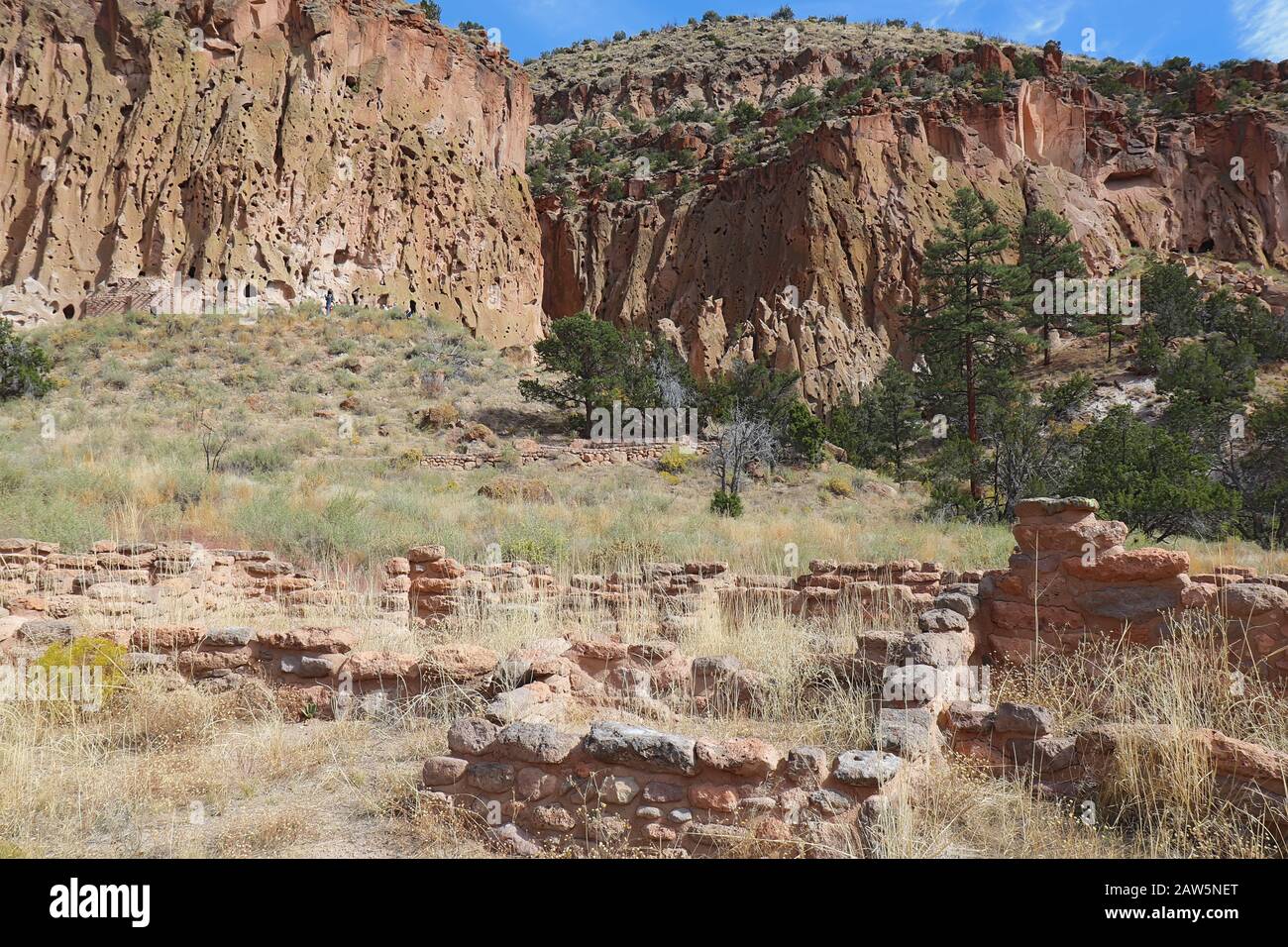 Parte delle rovine Tyuonyi dei popoli ancestrali Pueblo con un pueblo ricostruito dalle scogliere lungo il percorso principale del Canyon Frijoles a Ba Foto Stock