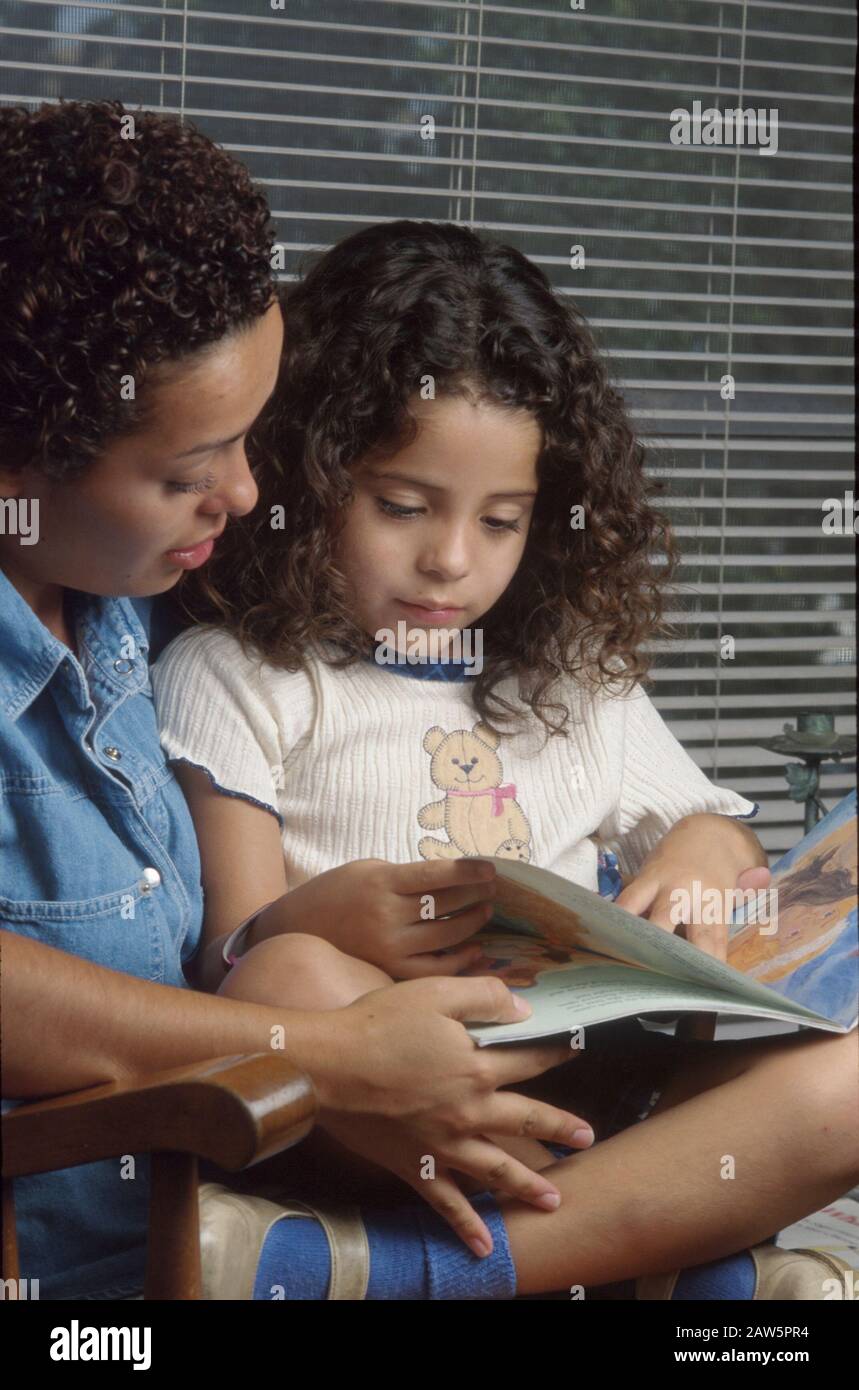 La madre ispanica di 26 anni legge con la figlia di quattro anni a casa loro a Austin, Texas. Foto Stock