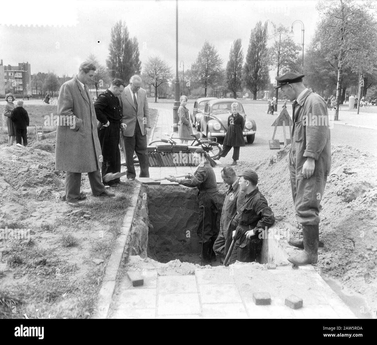 Nell'area compresa tra Apollolaan e H.B.S. distrutta al Gerrit van der Veenstraat di Amsterdam, sono occupati a finire con lo scavo di una bomba inesplosa che lì durante il bombardamento della Enterpestraat. Uomini Della bomba Disposizione e la difesa civile a lavorare. Data: 16 Maggio 1955 Località: Amsterdam, Noord-Holland Parole Chiave: Bombe, Esplosivi Foto Stock