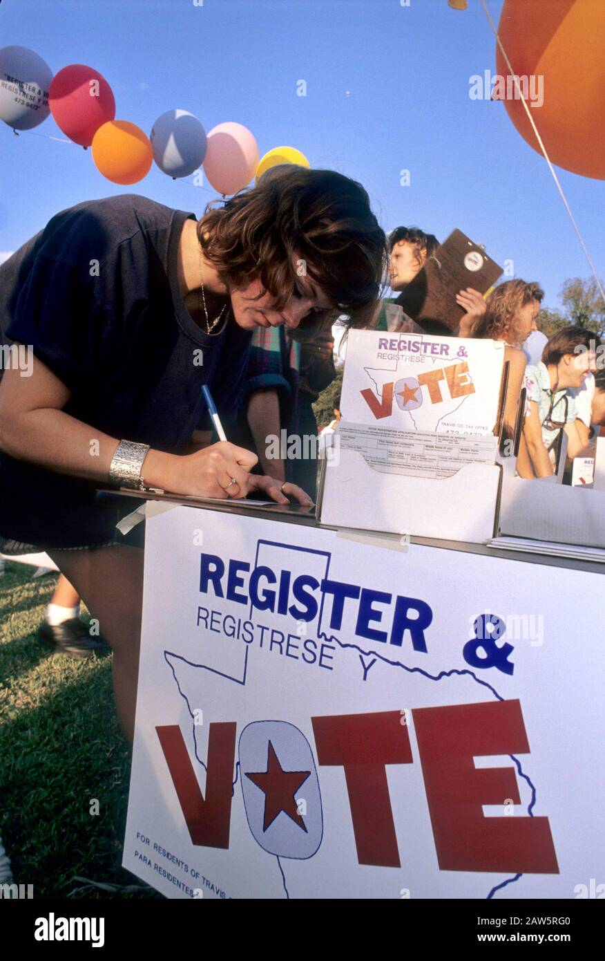 Giovane donna compila una carta di registrazione elettorale durante un rally politico all'aperto ad Austin, Texas. Foto Stock