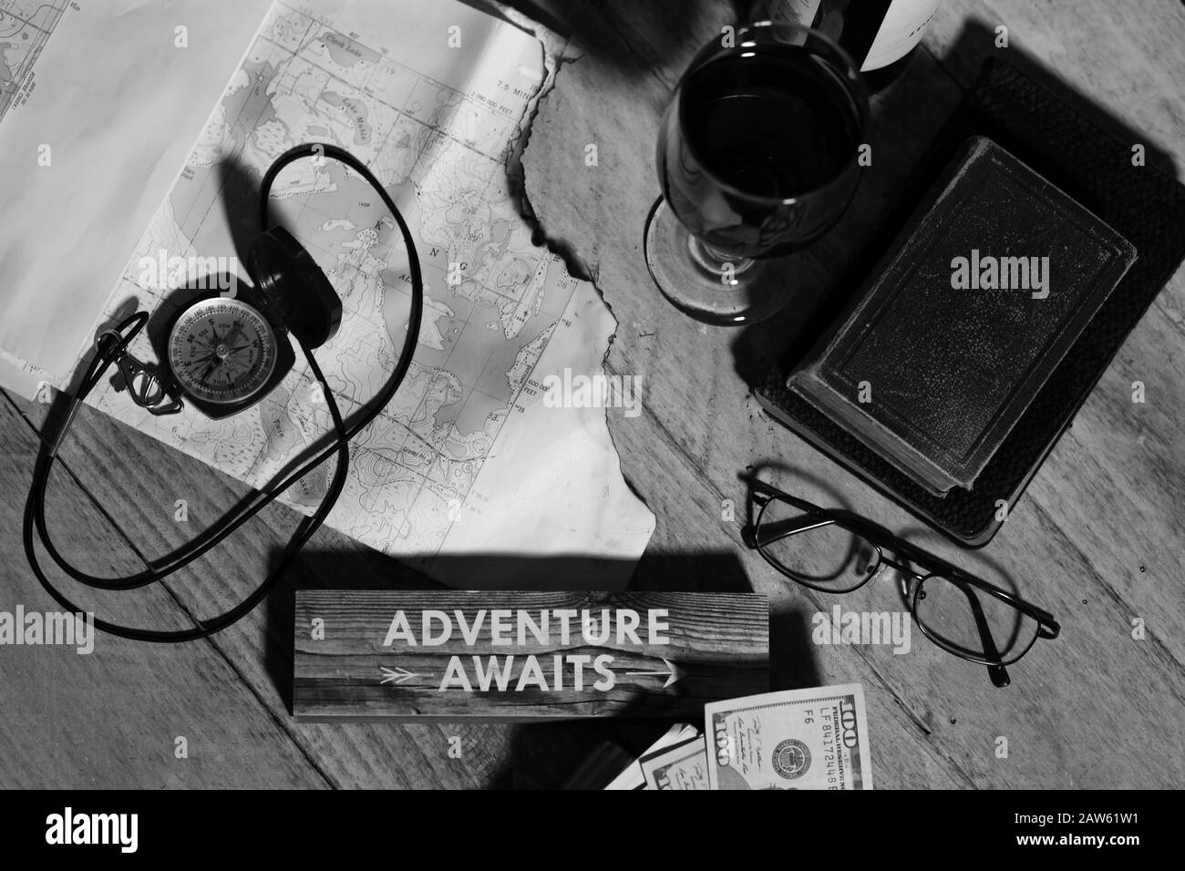 Mappa, bussola, vino, denaro, libri e bicchieri, avventura attende concetto, blcack e bianco Foto Stock