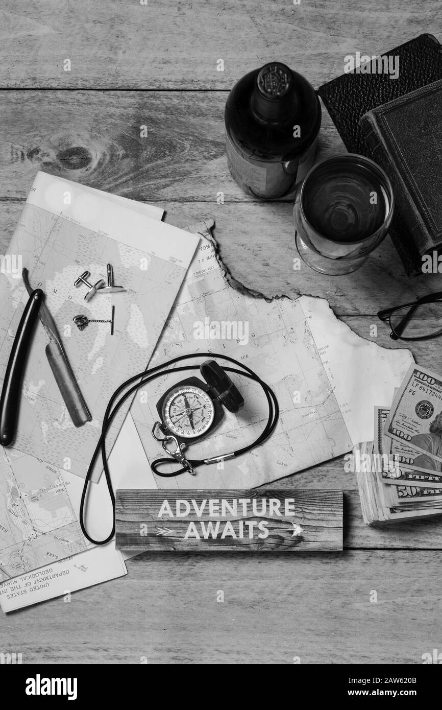 Mappa, Bussola, vino, denaro, libri, rasoio, polsini, tie tack e bicchieri pronti per un viaggio concetto, in bianco e nero Foto Stock