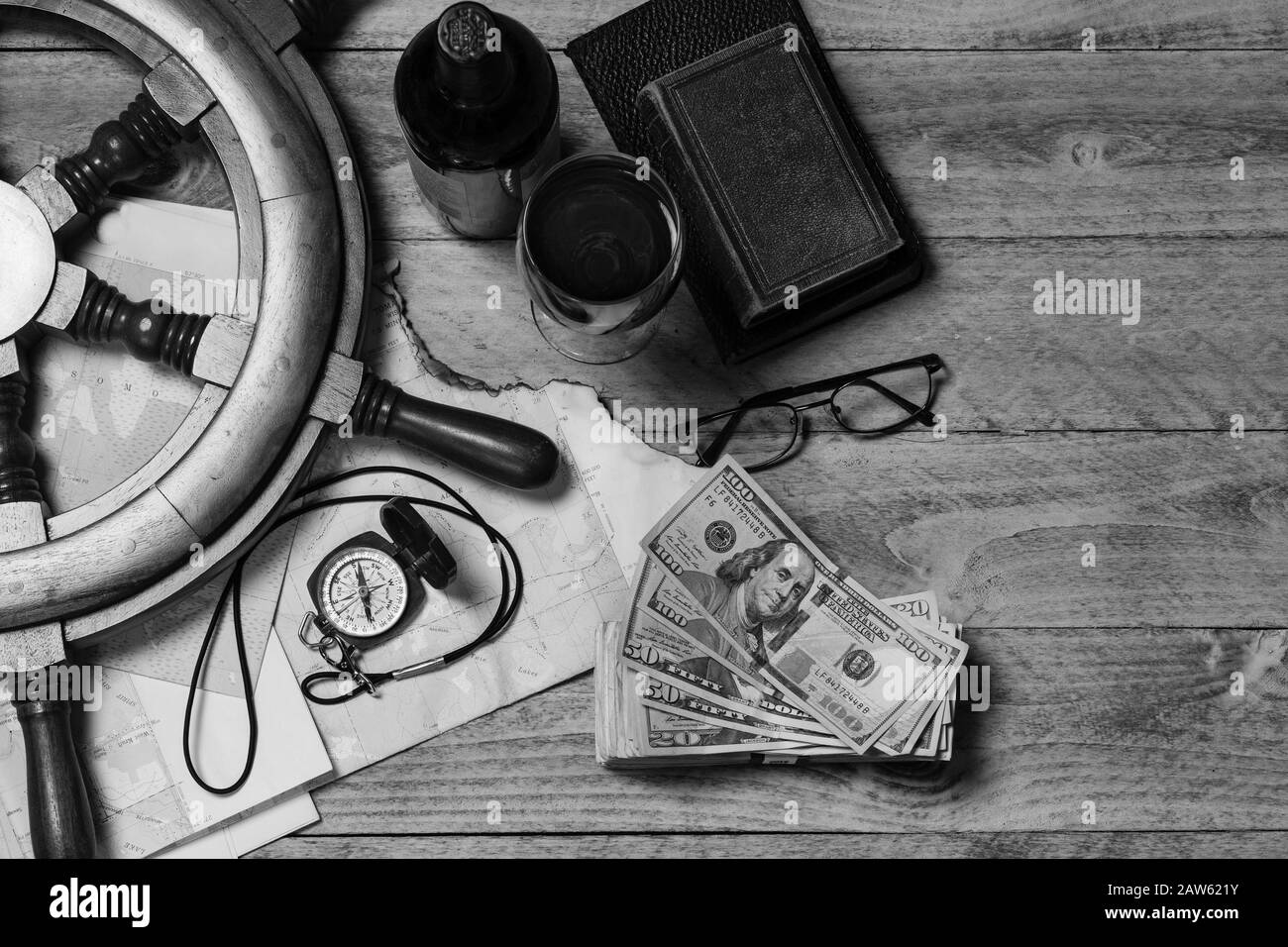 Mappa, Bussola, vino, denaro, libri, nave volante e bicchieri pronti per un viaggio concetto, in bianco e nero Foto Stock