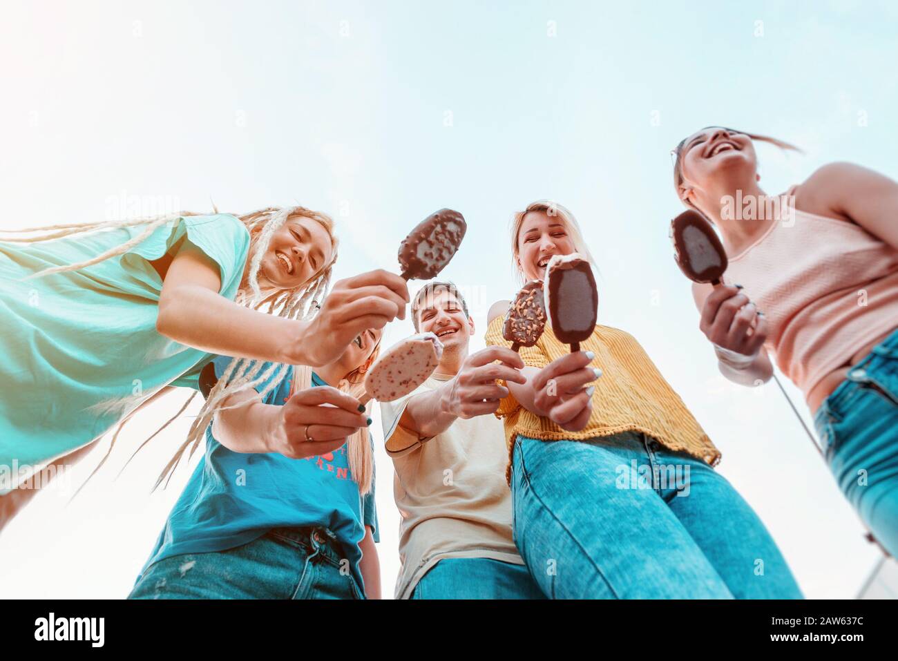 Gruppo di giovani che mangiano gelato e sorridono Foto Stock