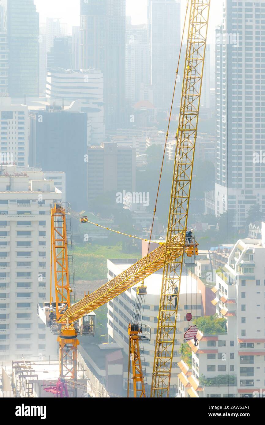 Veduta aerea di un cantiere con equipaggio di costruzione gru torre in un giorno torbido. Foto Stock