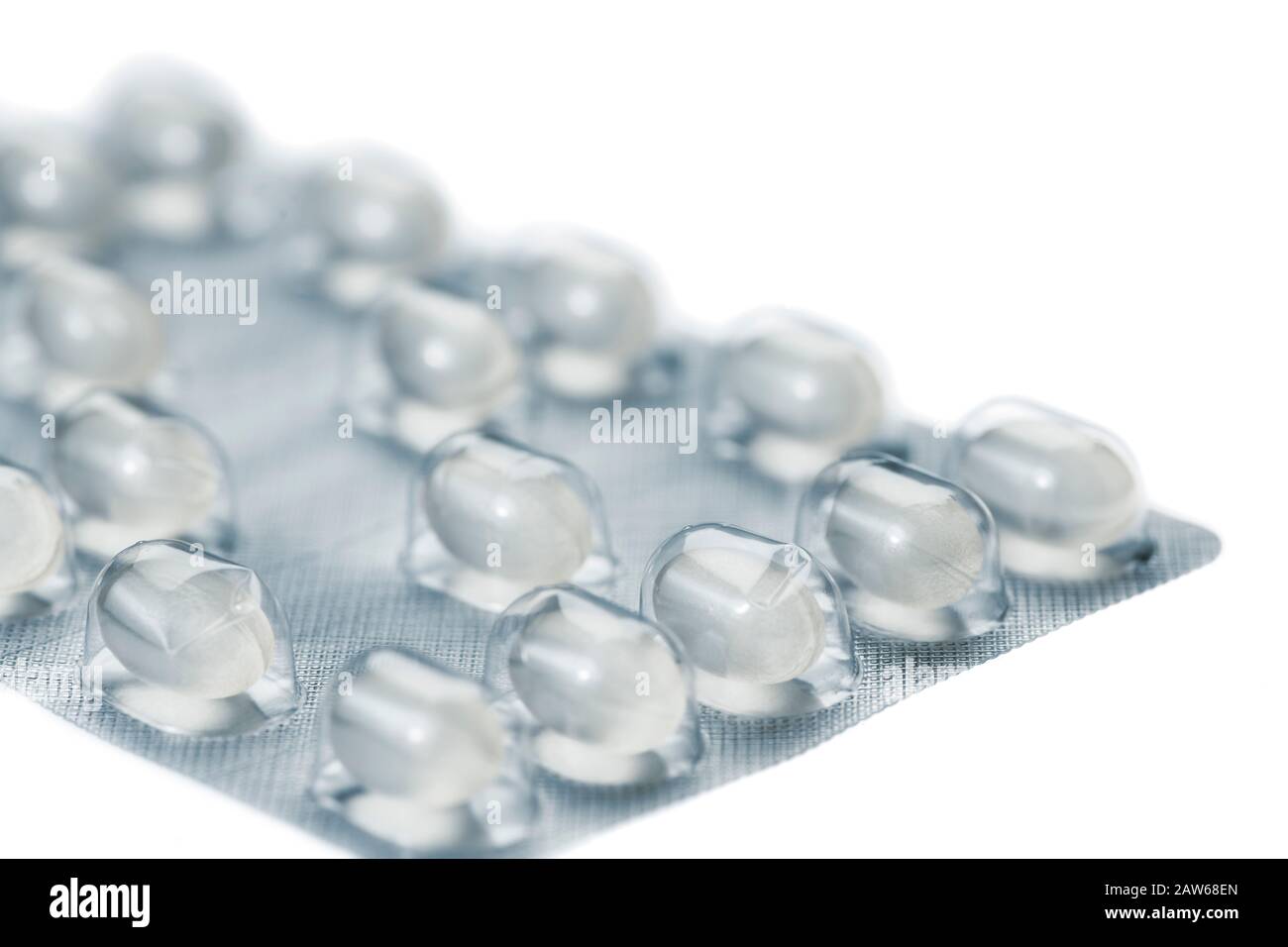 Primo piano dell'angolo di una confezione in lamina per capsule di compresse isolate su sfondo bianco senza ombra. Foto Stock