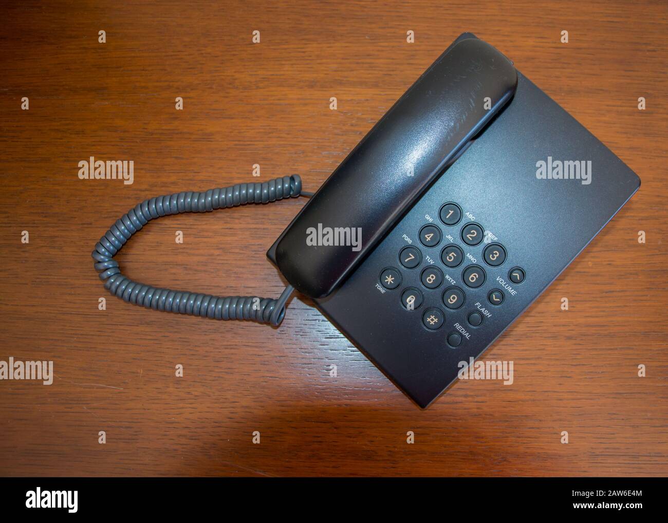 Nuovo e moderno telefono nero su sfondo di legno, telefono su una scrivania, concetto di business, in ufficio Foto Stock