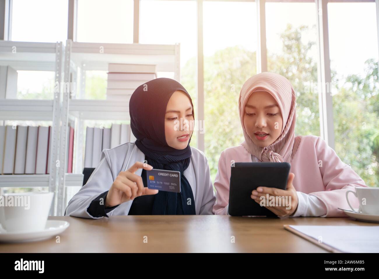 Donna musulmana business in abbigliamento tradizionale shopping online e pagamento con carta di credito Foto Stock
